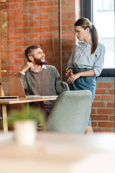 Selektive Fokussierung unzufriedener Geschäftsfrau auf fröhliche Mitarbeiterin im Büro — Stockfoto