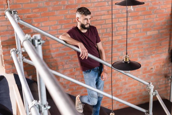 Вибірковий фокус бородатого бізнесмена, що стоїть на сходах в сучасному офісі — стокове фото