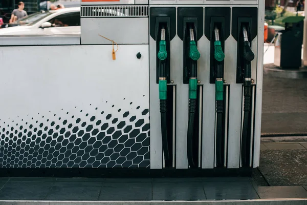 Fueling nozzles on car refueling station on urban street — Stock Photo