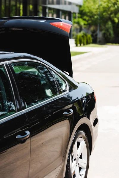 Black auto with open trunk on urban street — Stock Photo