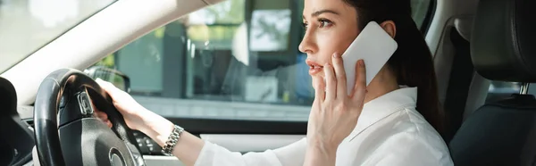 Foto panoramica di bella donna d'affari che parla su smartphone e guida auto — Foto stock