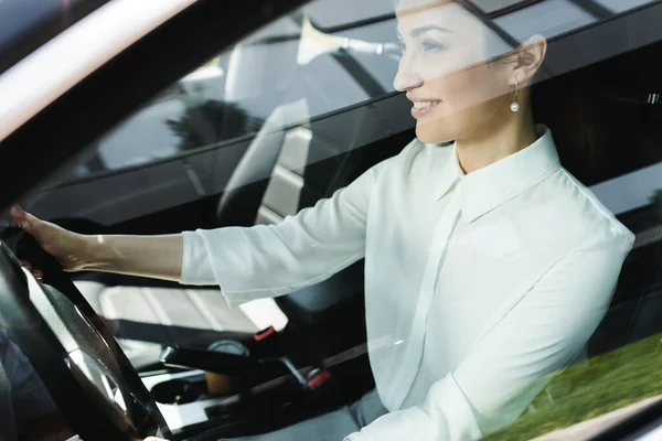 Focus sélectif de souriante femme d'affaires au volant d'une voiture — Photo de stock