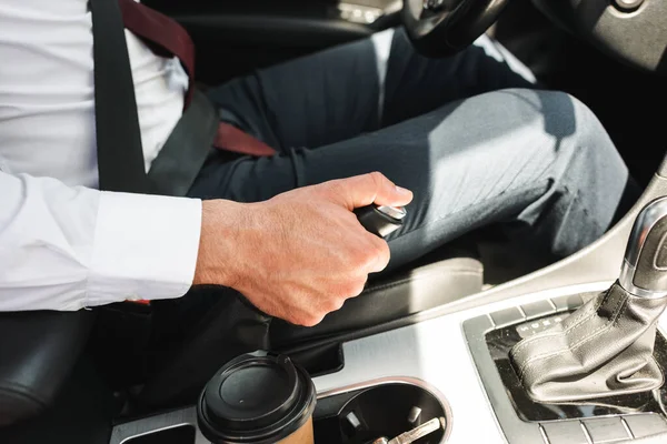 Vista cortada de homem de negócios em uso formal carro de condução perto de café para ir em suporte de copo — Fotografia de Stock