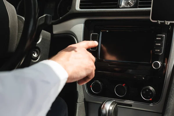 Обрезанный взгляд бизнесмена с использованием автомобильной аудиосистемы в авто — стоковое фото