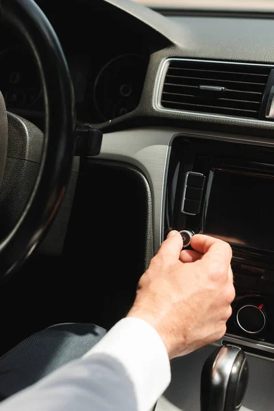 Vista cortada do empresário ajustando o volume do sistema de áudio do veículo em auto — Fotografia de Stock