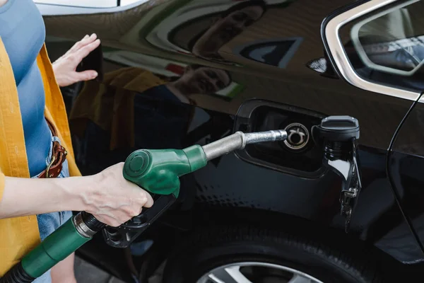 Vista cortada de mulher reabastecendo carro no posto de gasolina — Fotografia de Stock