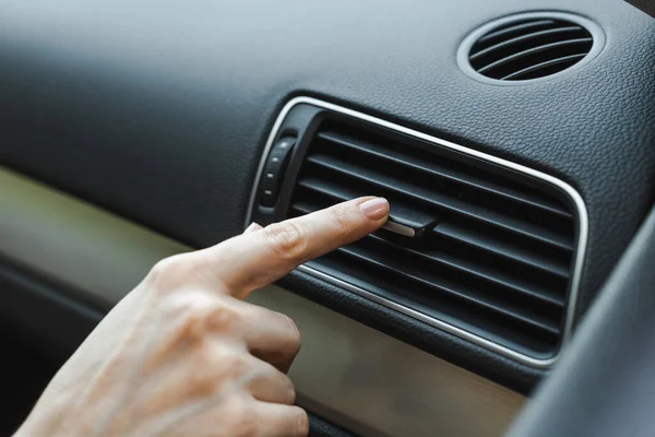 Cropped view of woman adjusting air conditioner in car — Stock Photo