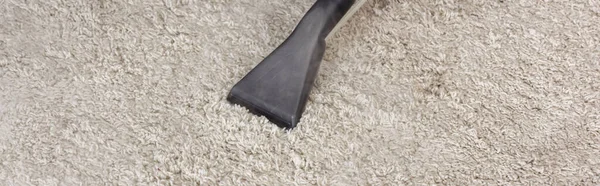 Coltivazione panoramica di spazzola di aspirapolvere su tappeto a casa — Foto stock