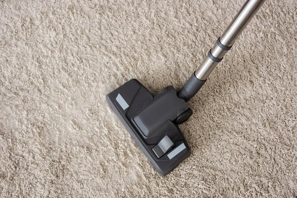 Vue du dessus de la brosse de l'aspirateur sur tapis beige — Photo de stock