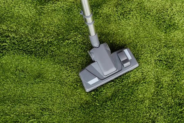 Top view of vacuum cleaner on green carpet — Stock Photo