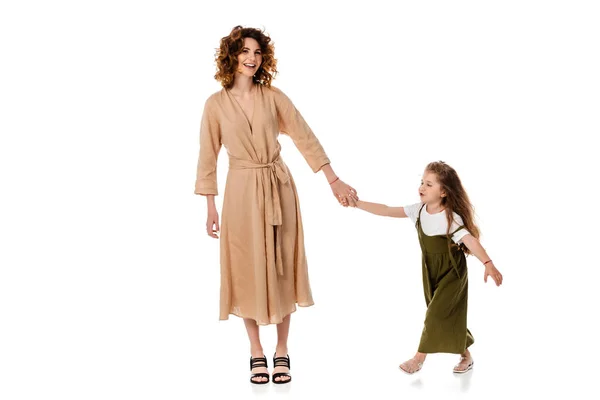 Curly mother and cute daughter holding hands isolated on white — Stock Photo