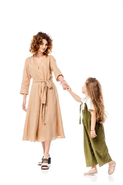 Curly mother and daughter holding hands isolated on white — Stock Photo