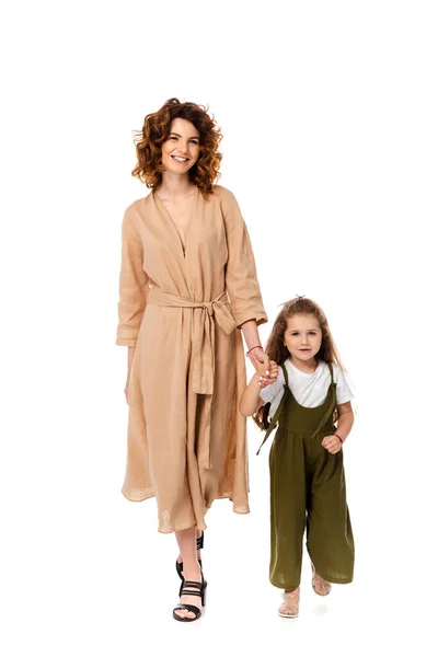 Sonrientes madre e hija cogidas de la mano aisladas en blanco - foto de stock