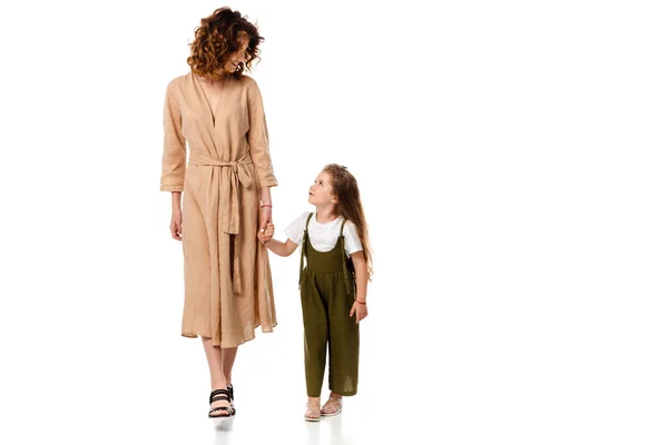 Cheerful mother and adorable daughter holding hands isolated on white — Stock Photo