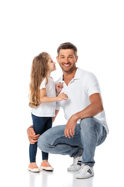 Niedliche Tochter schaut glücklichen Vater an, der auf Weiß sitzt — Stockfoto