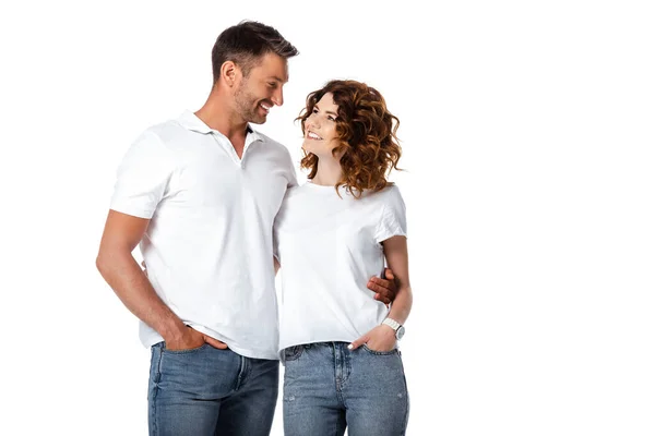 Heureux homme et femme debout avec les mains dans les poches tout en se regardant isolé sur blanc — Photo de stock