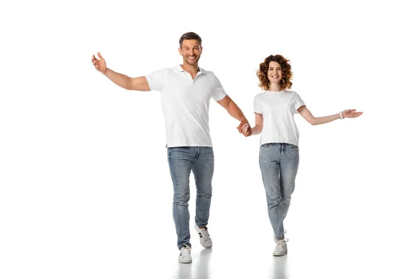Femme heureuse et homme joyeux tenant la main tout en marchant sur blanc — Photo de stock