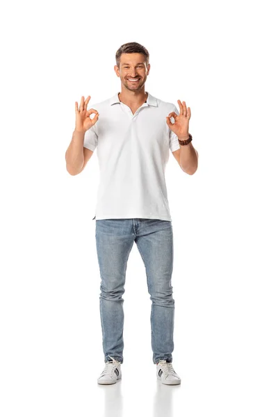 Веселий чоловік, що показує знак ОК і стоїть на білому — стокове фото