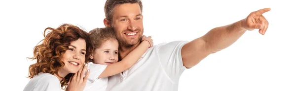 Récolte horizontale de père heureux pointant avec le doigt près de femme gaie et enfant isolé sur blanc — Photo de stock