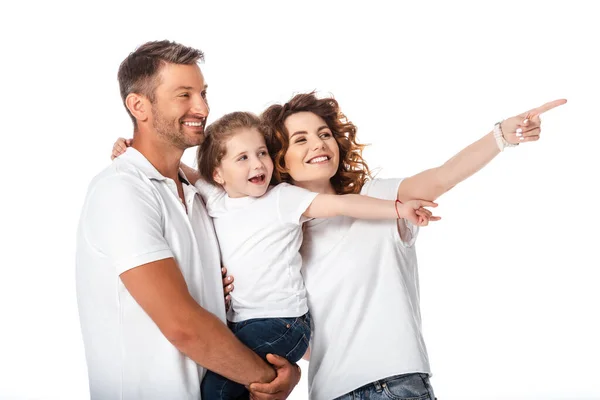 Glückliche Mutter zeigt mit dem Finger in die Nähe eines fröhlichen Ehemannes, der ein Kind in den Armen hält, das auf weiß isoliert ist — Stockfoto