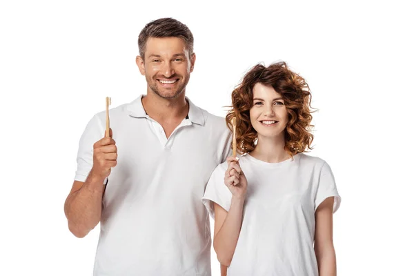 Cheerful couple holding toothbrushes isolated on white — Stock Photo