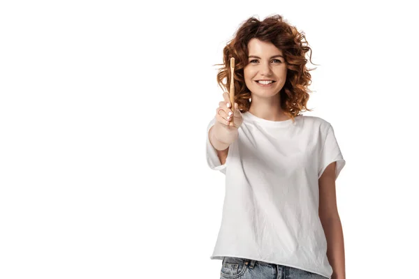 Selective focus of cheerful and curly woman holding toothbrush isolated on white — Stock Photo