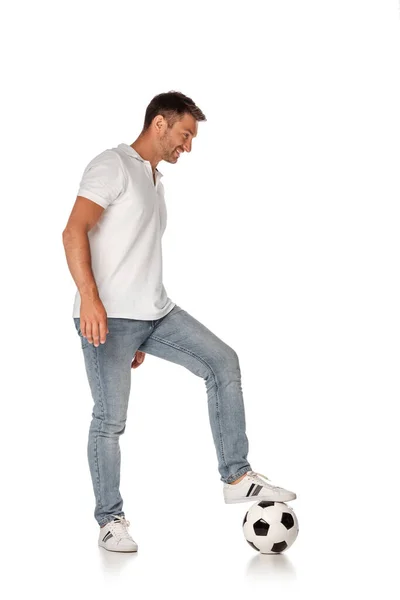 Glücklicher Mann in Jeans, der Fußball auf Weiß spielt — Stockfoto