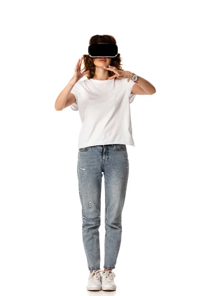 Curly woman in virtual reality headset gesturing on white — Stock Photo
