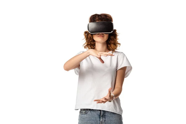 Lockige junge Frau in Virtual-Reality-Headset gestikuliert isoliert auf weiß — Stockfoto