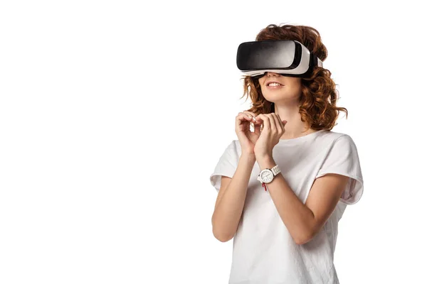 Mulher encaracolado em fone de ouvido realidade virtual mostrando coração com as mãos isoladas no branco — Fotografia de Stock