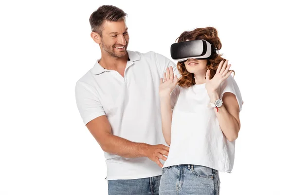 Homem feliz olhando para a mulher assustada no fone de ouvido realidade virtual gesticulando isolado no branco — Fotografia de Stock
