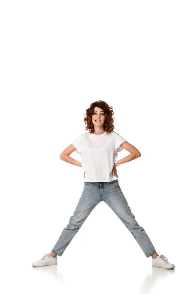 Femme émotionnelle debout avec les mains sur les hanches et les lèvres piquantes sur blanc — Photo de stock