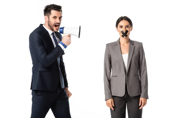 Bärtige Geschäftsfrau schreit in Megafon in der Nähe Geschäftsfrau mit Klebeband auf dem Mund isoliert auf weiß, Geschlechterungleichheit Konzept — Stockfoto