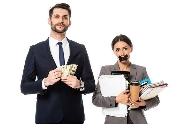 Handsome businessman holding dollars near businesswoman with duct tape on mouth isolated on white, sexism concept — Stock Photo