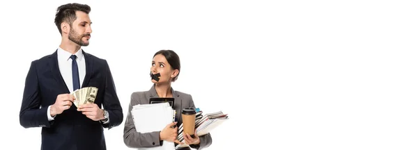 Panoramic crop of handsome businessman holding dollars near businesswoman with duct tape on mouth isolated on white, sexism concept — Stock Photo
