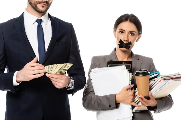 Bearded businessman holding dollars near businesswoman with duct tape on mouth isolated on white, sexism concept — Stock Photo