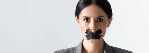 Panoramic orientation of businesswoman with scotch tape on mouth isolated on white — Stock Photo