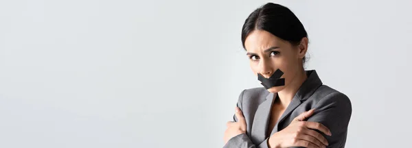 Сайт заголовок деловой женщины с скотчем на рту стоя со скрещенными руками изолированы на белом — стоковое фото