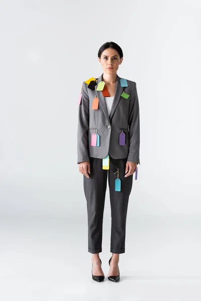 Бізнесниця з етикетками на офіційному одязі стоїть на білій концепції гендерної нерівності — стокове фото