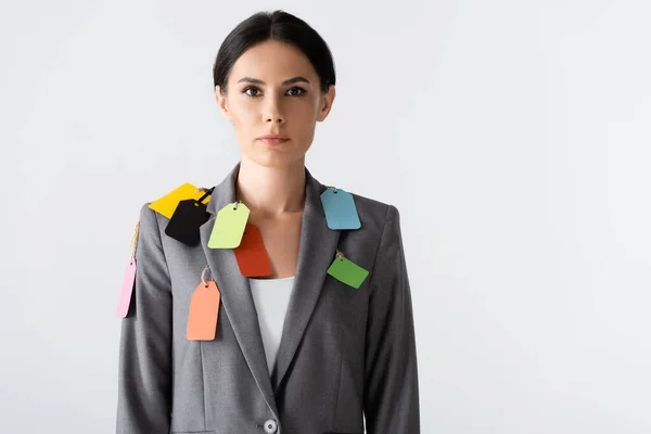 Attractive businesswoman with labels on formal wear standing isolated on white, gender inequality concept — Stock Photo