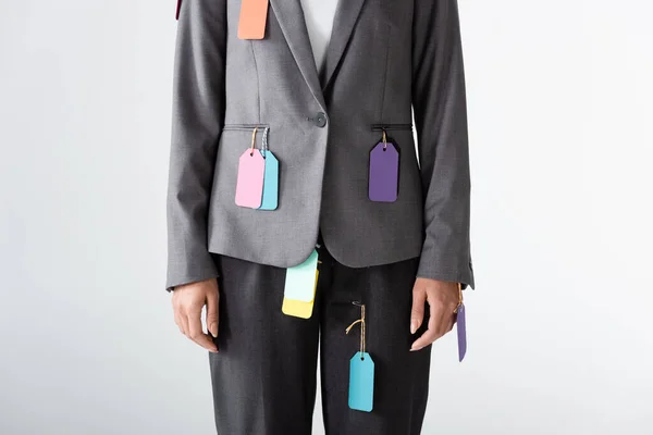 Vista ritagliata di donna d'affari con etichette su abbigliamento formale in piedi isolato su bianco, concetto di disuguaglianza di genere — Foto stock
