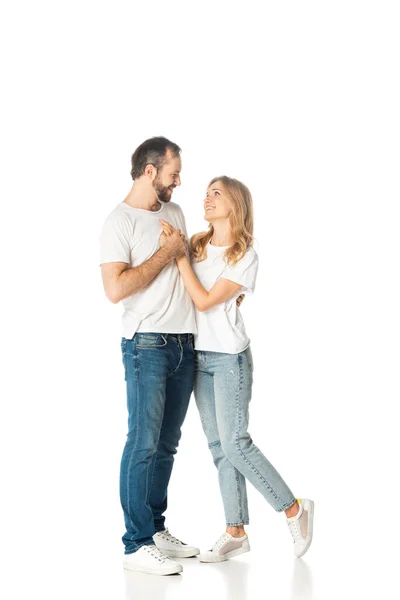Happy adult couple in white t-shirts embracing and holding hands isolated on white — Stock Photo