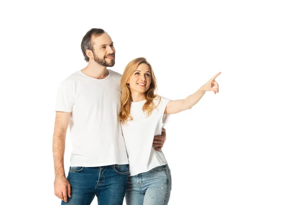 Fröhliches erwachsenes Paar in weißen T-Shirts, das mit dem Finger zur Seite zeigt — Stockfoto