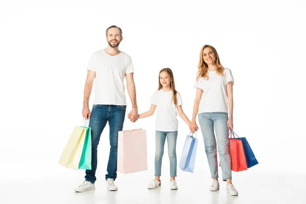 Cheerful family with colorful shopping bags holding hands isolated on white — Stock Photo