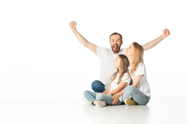 Glückliche Familie sitzt mit überkreuzten Beinen auf dem Boden, während Mann Ja-Geste zeigt, isoliert auf Weiß — Stockfoto