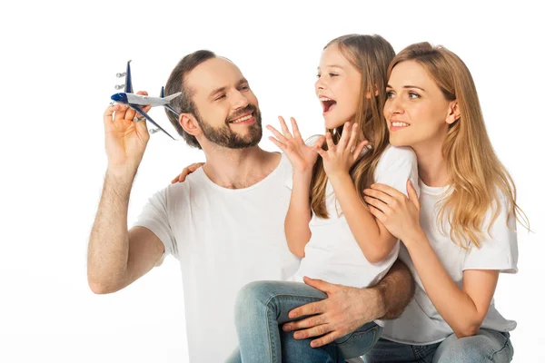 Glücklich lächelnde Familie mit Flugzeugmodell isoliert auf weiß — Stockfoto