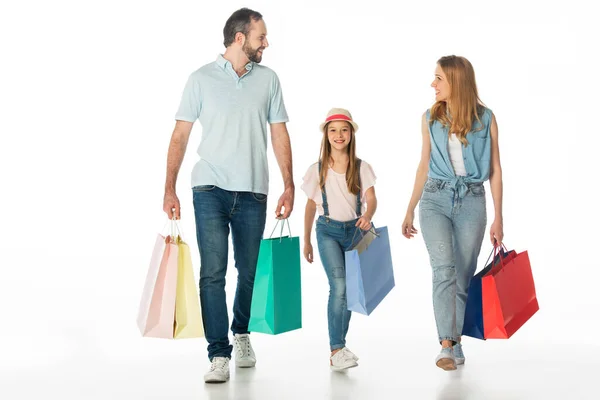 Família feliz andando com sacos de compras coloridos isolados no branco — Fotografia de Stock
