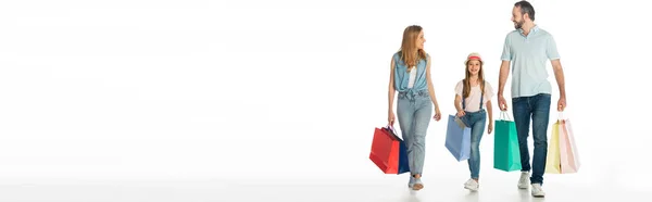 Familia feliz caminando con coloridas bolsas de compras aisladas en blanco, plano panorámico - foto de stock