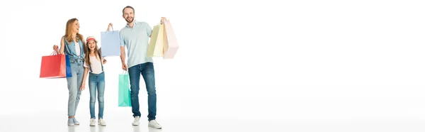 Família feliz com sacos de compras coloridos isolados em branco, tiro panorâmico — Fotografia de Stock