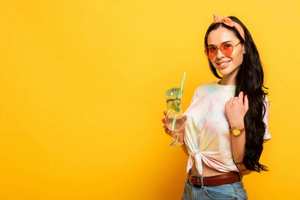 Sorridente elegante ragazza bruna estiva con cocktail rinfrescante su sfondo giallo — Foto stock
